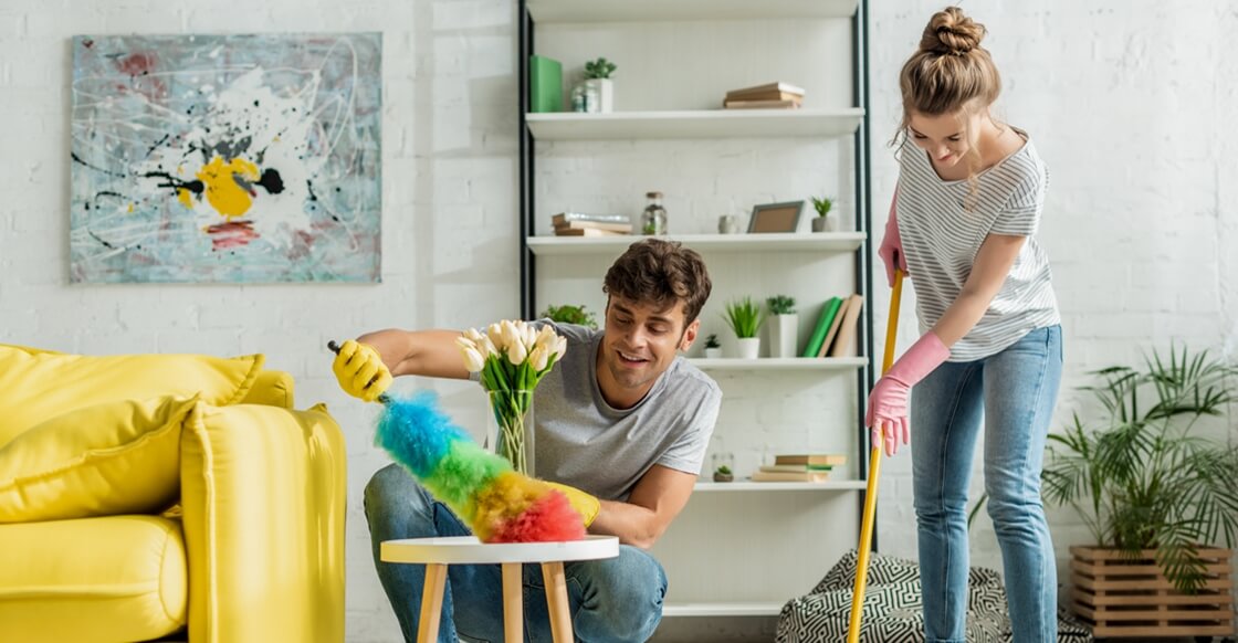 Young couple cleaning their living room.