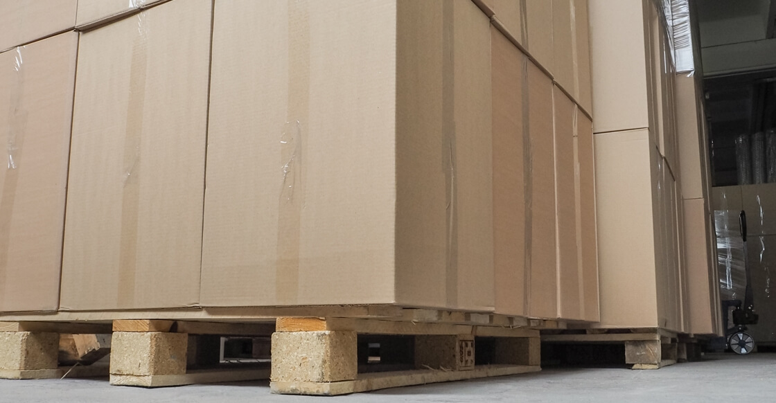 Pallets with cardboard boxes stored inside a self-storage unit.