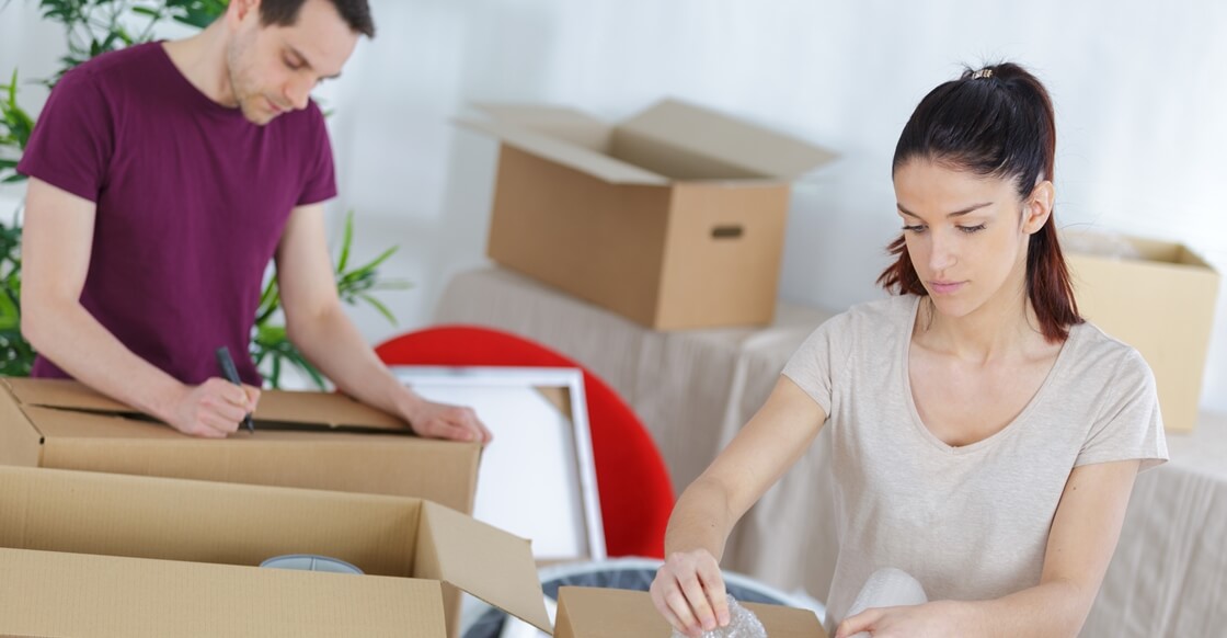 Young couple packing their belongings for long term self-storage.