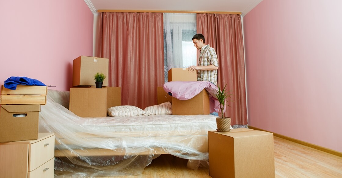 Man packing bedroom items for a house move.