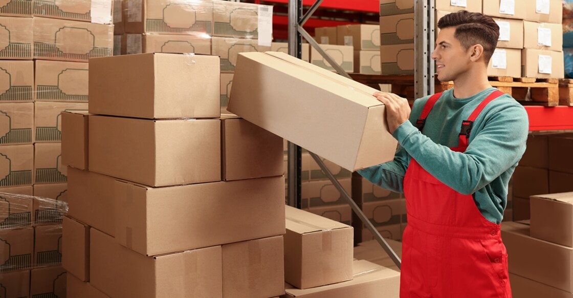 worker stacking boxes inside a business storage unit.