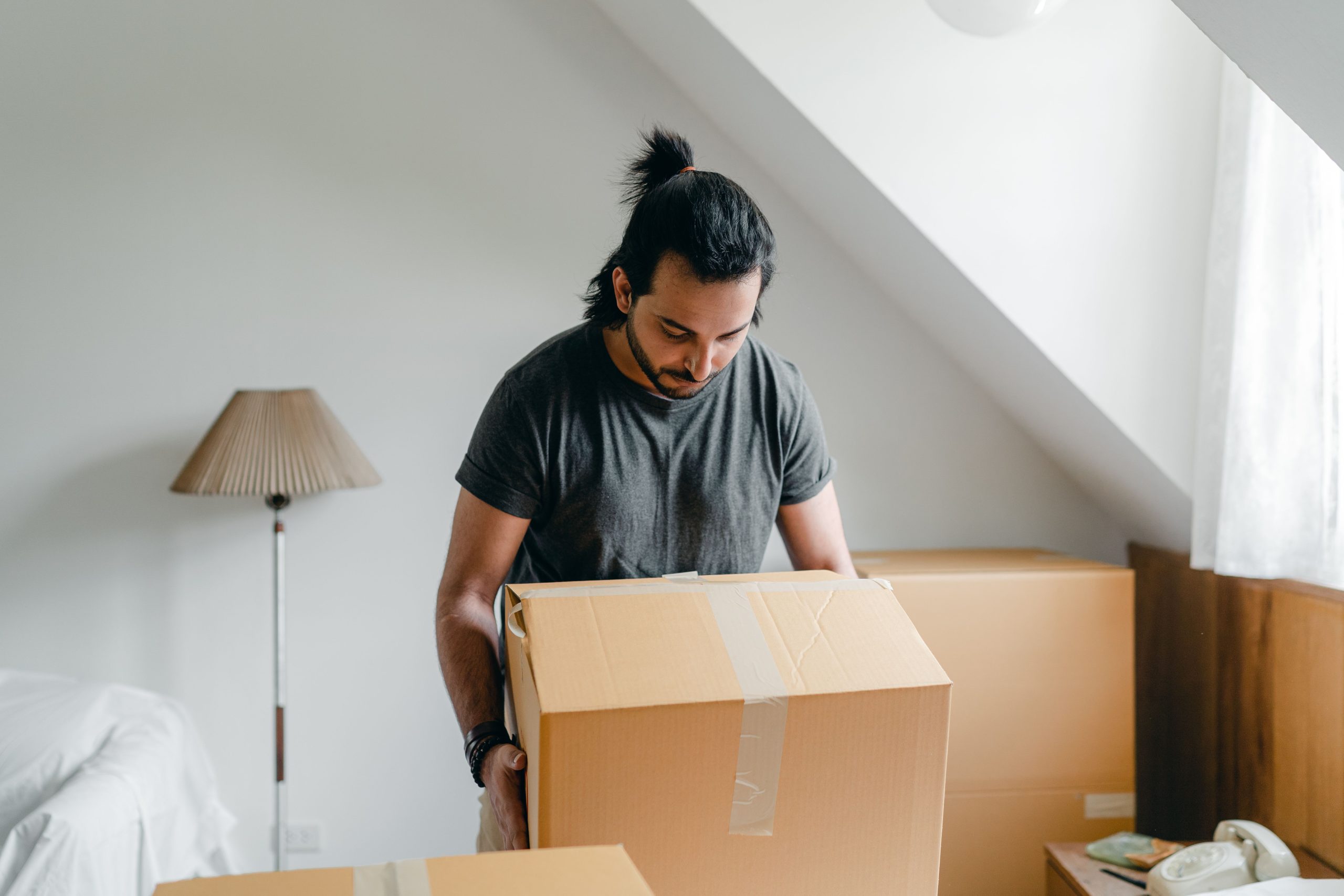man packing boxes from his attic room